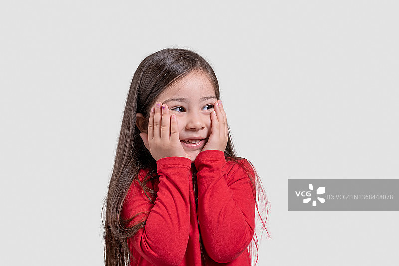 双手放在脸颊上的快乐儿童女孩肖像图片素材