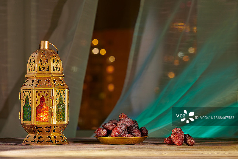 斋月期间的穆斯林盛宴，传统灯笼和木桌上的枣图片素材