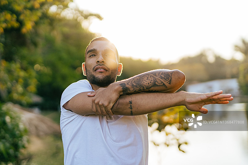 在日落时分的公园里伸展身体的运动员图片素材