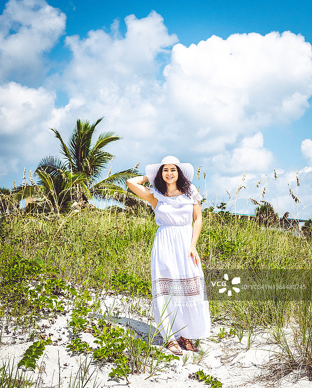 在旅游胜地海滩度假时，戴着遮阳帽的加勒比黑人妇女的微笑肖像图片素材