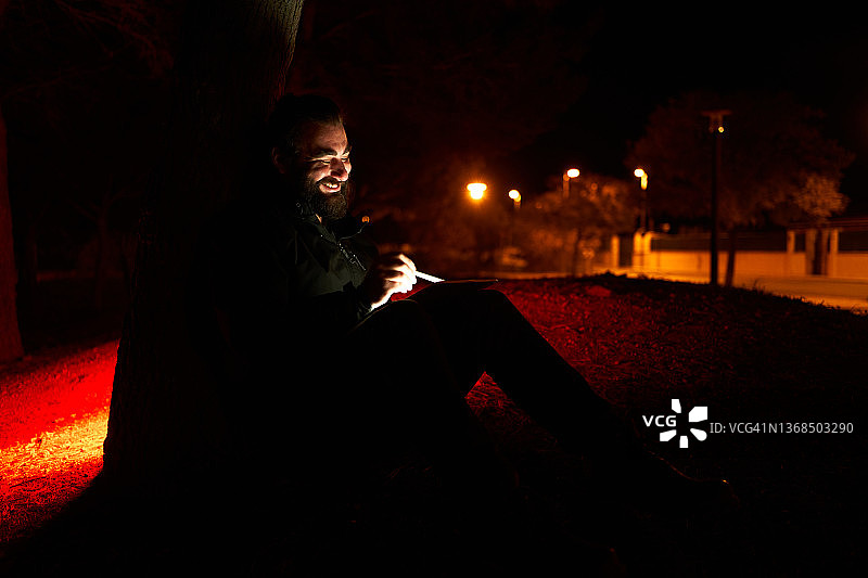 快乐的男人在黑暗的公园里写生图片素材