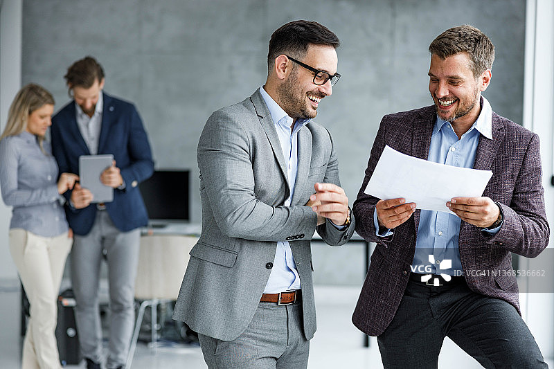 在办公室撰写报告的快乐商人图片素材