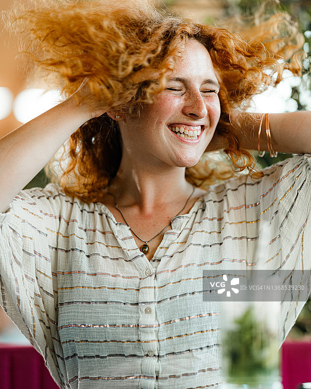 快乐的红发女人摇头玩耍图片素材