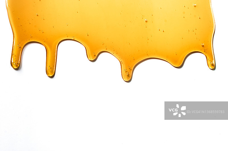 白色背景上的黄色蜂蜜滴图片素材