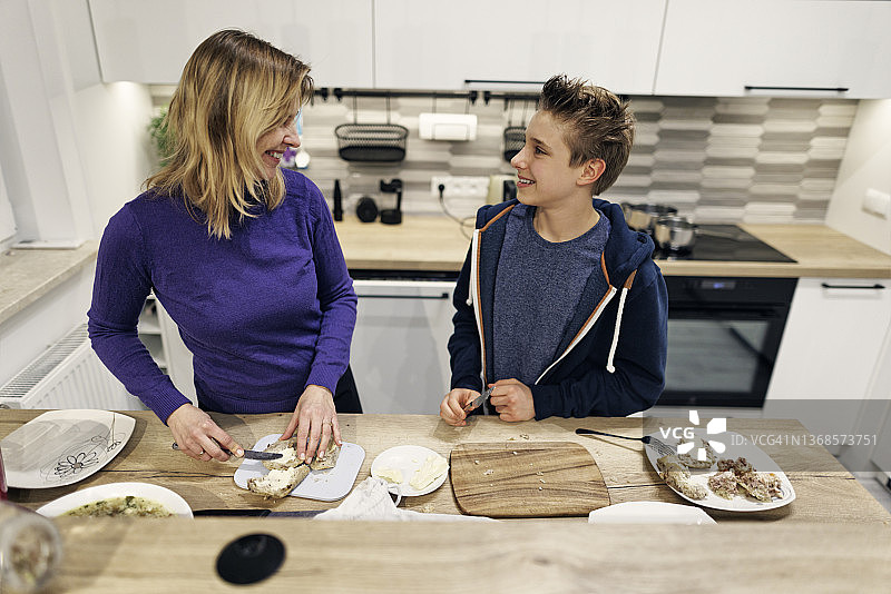 母亲和十几岁的儿子准备饭菜图片素材