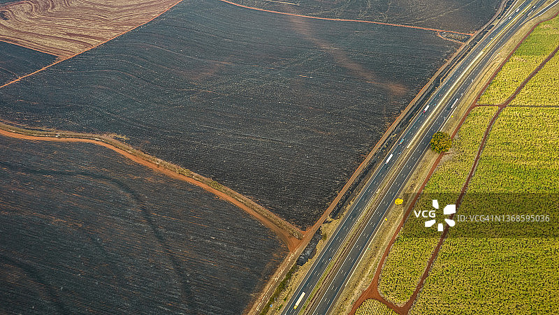 被高速公路隔开的烧毁的田地和绿色的田地图片素材