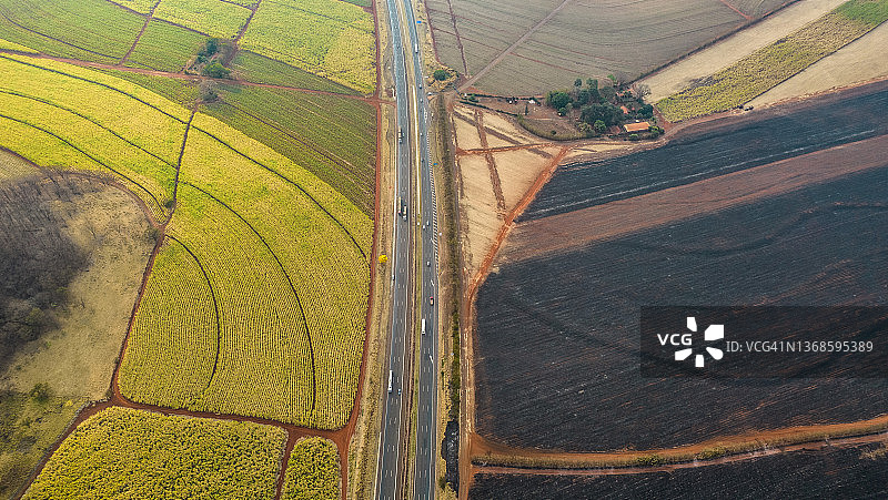 被高速公路隔开的烧毁的田地和绿色的田地图片素材