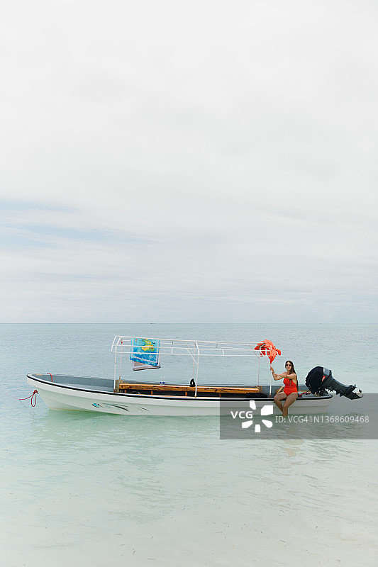 女游客在桑给巴尔岛的碧绿海水中乘船游览图片素材