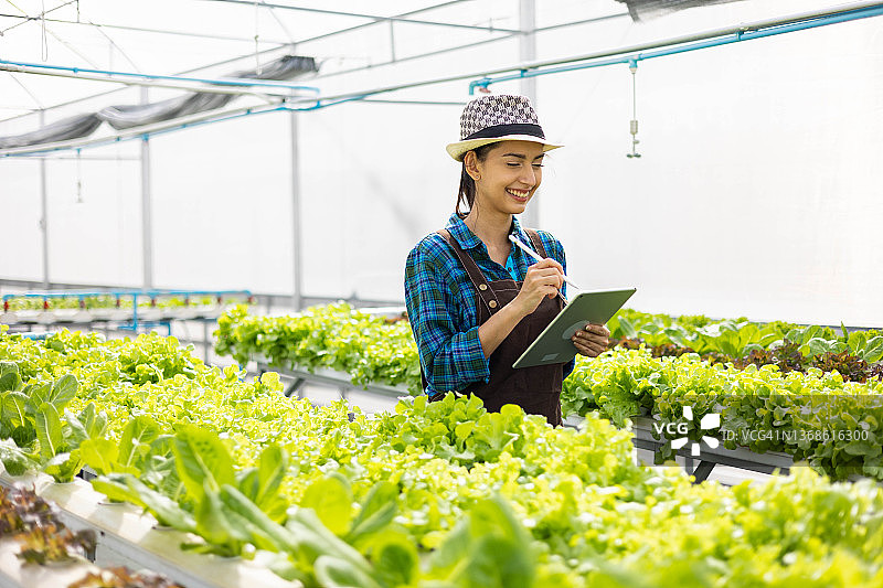 女工在温室中使用平板电脑图片素材