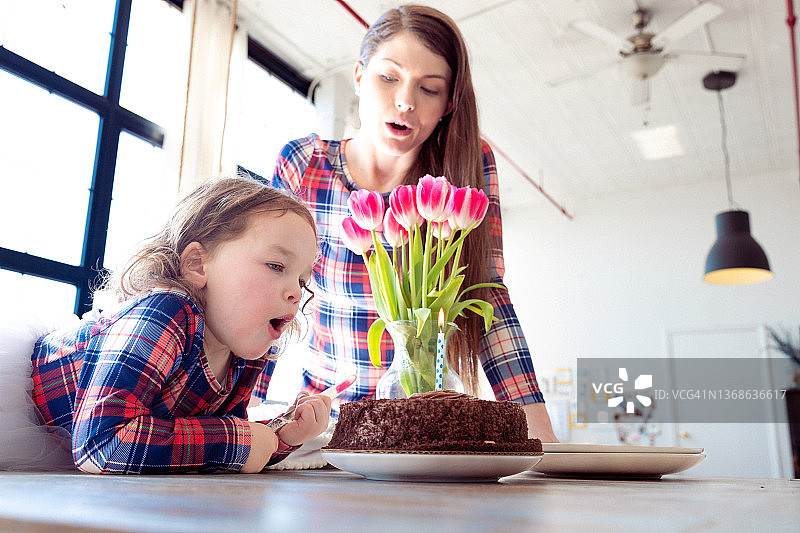 可爱的女婴吹生日蛋糕蜡烛图片素材