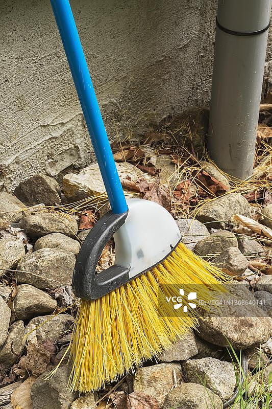 魁北克加拿大，靠在房屋外墙上的岩石边缘的扫帚图片素材