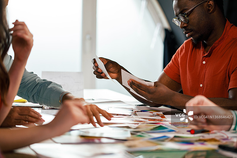 一群有创意的人整理照片以制作新的作品集图片素材