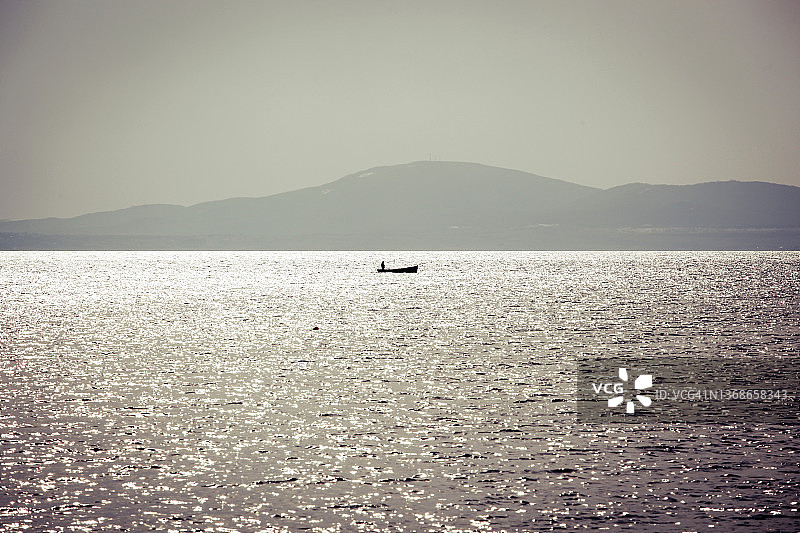 冬日海面上的孤独渔夫图片素材