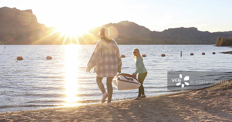 母女抬着皮划艇下湖图片素材