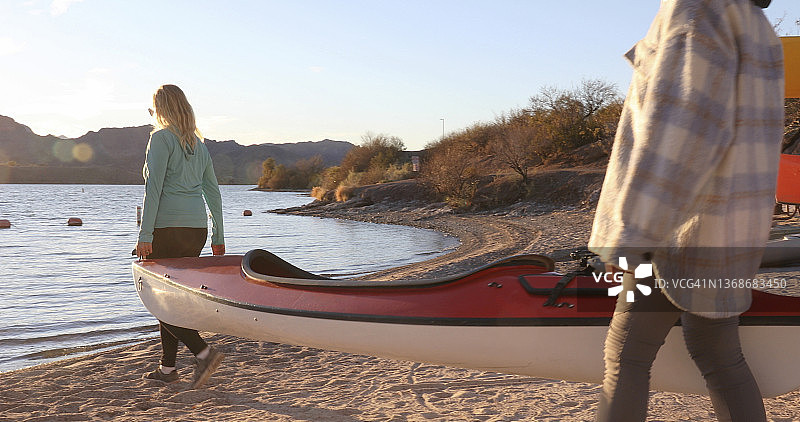 母女抬着皮划艇下湖图片素材