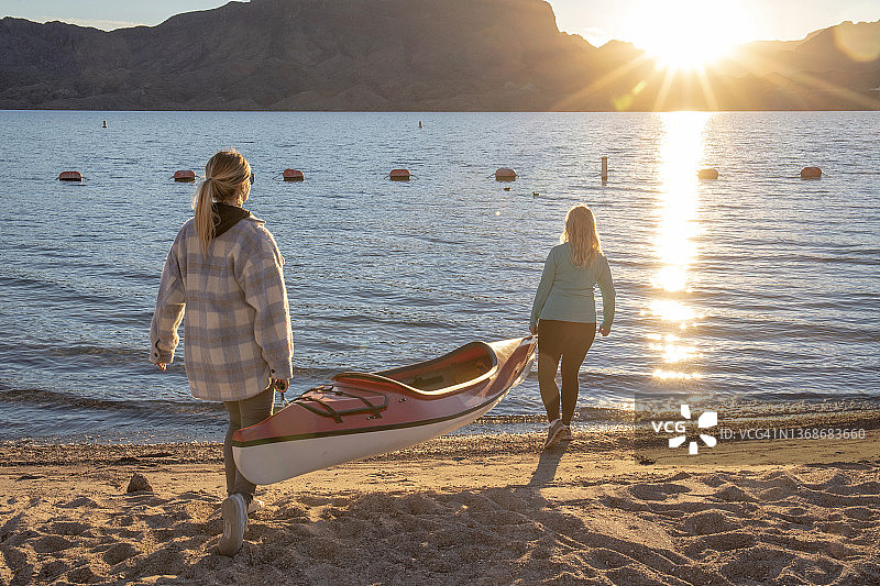母女抬着皮划艇下湖图片素材