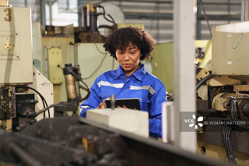 工厂里检查机械的工业女工程师图片素材