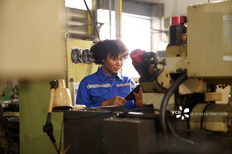 工厂里检查机械的工业女工程师图片素材