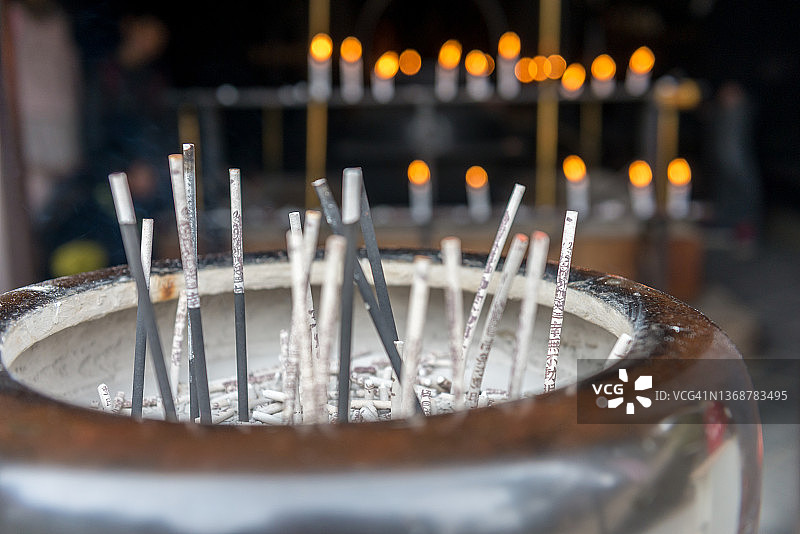 日本弥山附近，香在锅中燃烧的特写。背景中可以看到一些未聚焦的蜡烛火焰图片素材