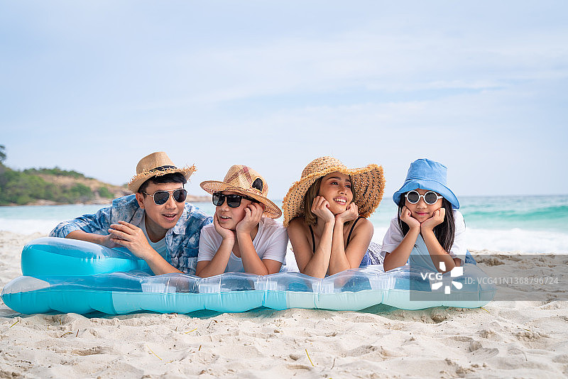 快乐的亚洲家庭在海滩上享受暑假图片素材