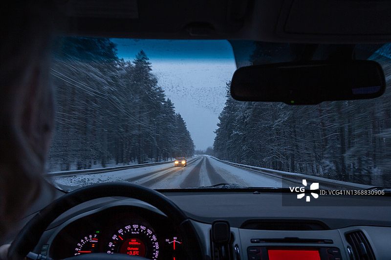 从车内看冬季森林夜间高速公路上的仪表盘和挡风玻璃图片素材