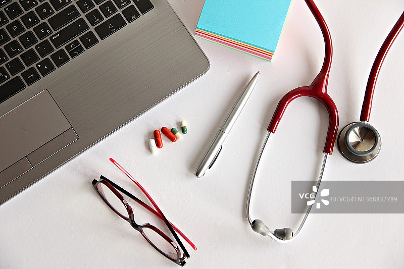 白色背景上的听诊器和笔记本电脑俯视图图片素材
