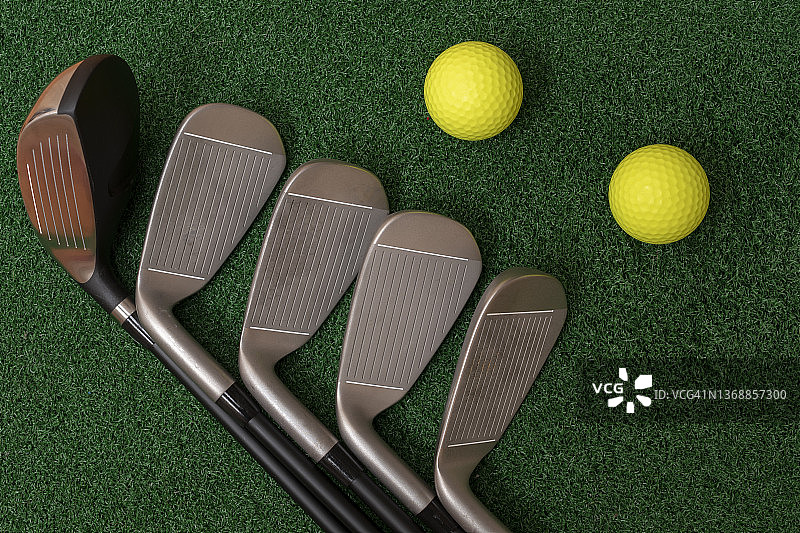 绿色草地上的高尔夫球杆和高尔夫球套装图片素材