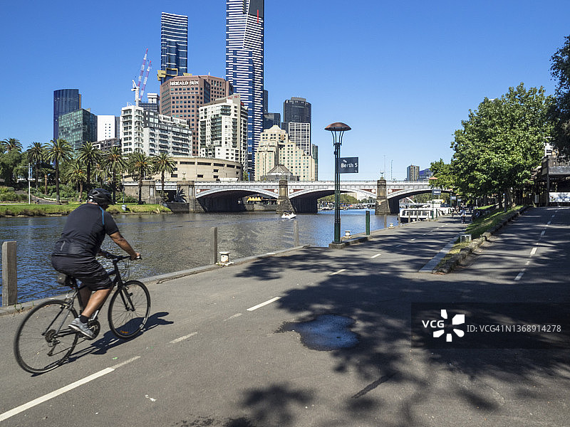 在雅拉河畔伯拉朗马尔公园骑自行车的男人图片素材