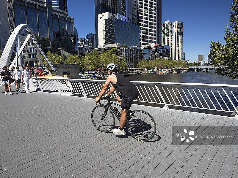 男自行车手在南岸人行桥上横穿亚拉河图片素材