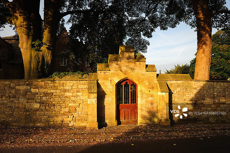 夕阳下的古老墙壁和大门，奇平卡姆登，科茨沃尔德小径，科茨沃尔德，英格兰图片素材