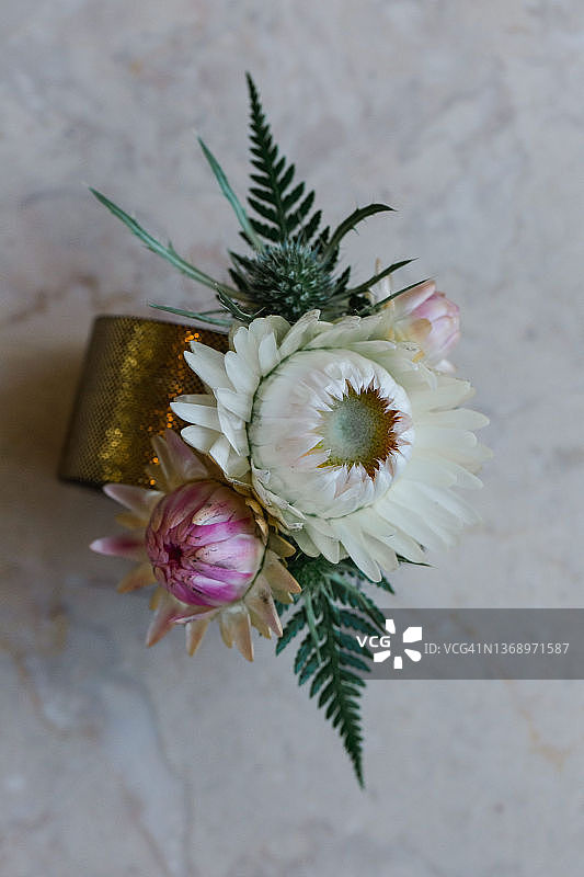 新娘母亲佩戴的金色手腕花饰：花朵和蕨类植物图片素材