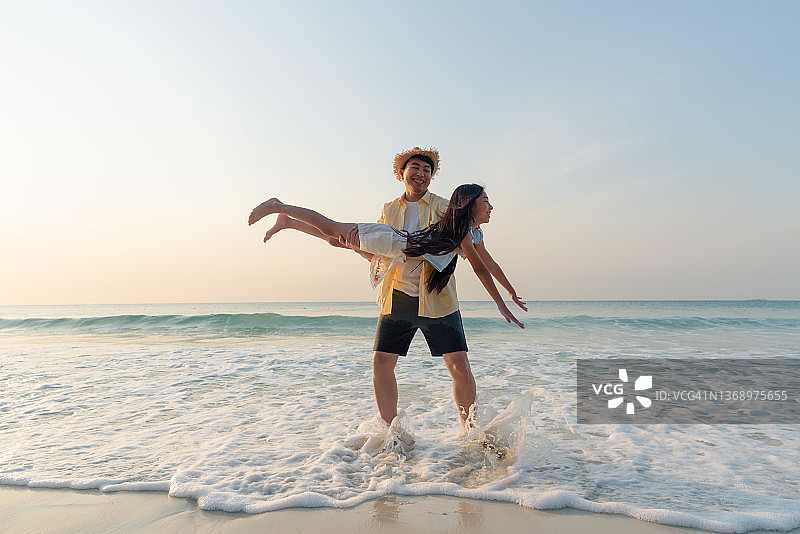 快乐的父亲和女儿在海滩度假图片素材