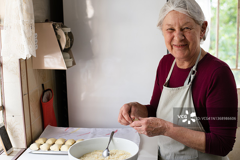 中年妇女做饭时看着镜头微笑图片素材
