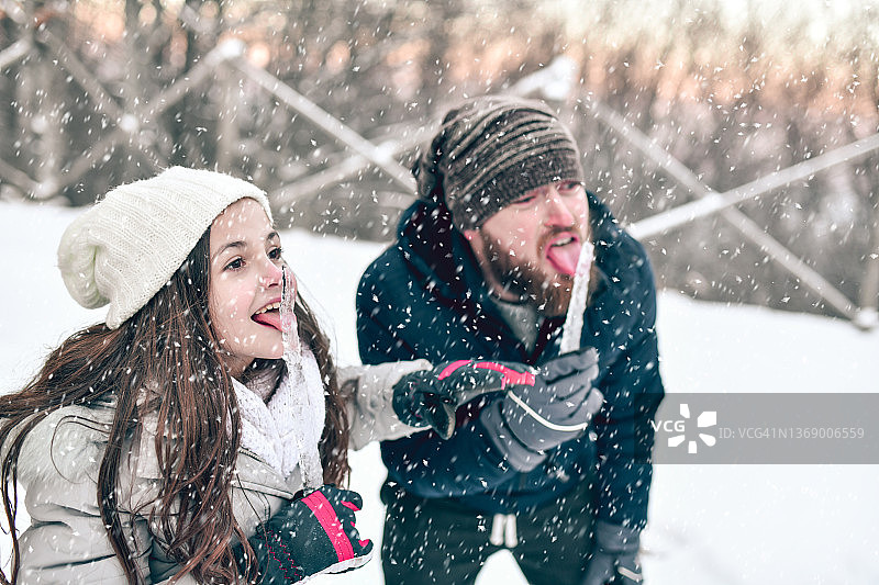 父女在雪山户外吃冰柱比赛图片素材