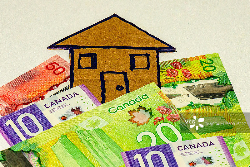 印有房屋图案的纸板上的不同面额的加拿大纸币图片素材
