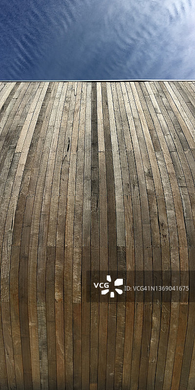 在高高的木墙下仰望蓝天的人图片素材
