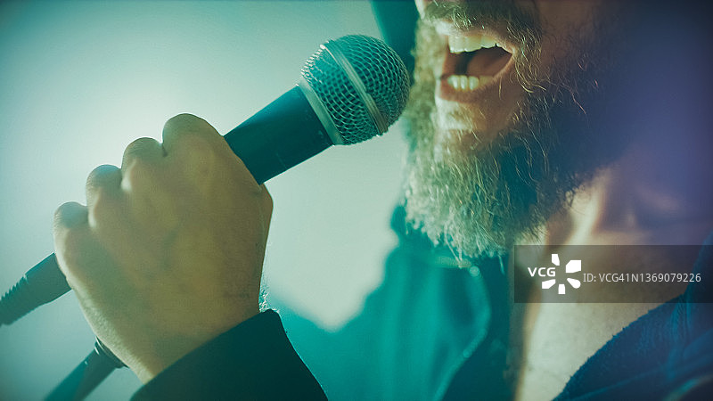 摇滚歌手在舞台灯光下现场演唱图片素材