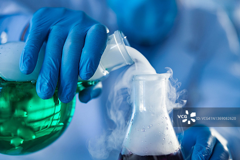 从实验室烧瓶中倾倒出的烟雾特写图片素材