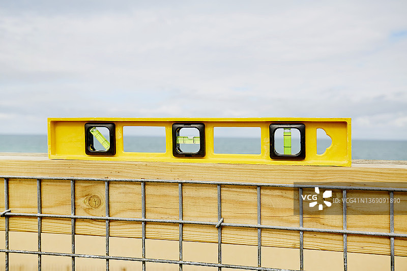 海天背景墙面上的黄色水平仪静物图片素材