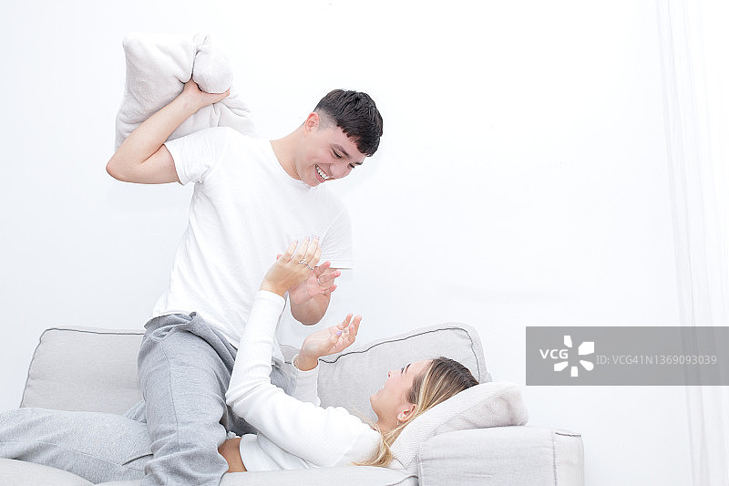 年轻夫妇枕头大战图片素材
