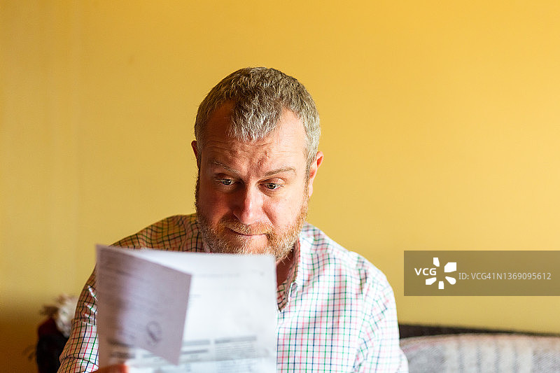 忧虑的男人在家查看账单图片素材
