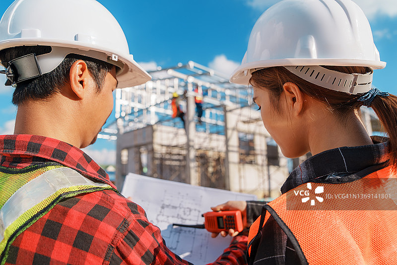 两位年轻建筑工程师讨论施工进度，工程师男女现场检查图片素材