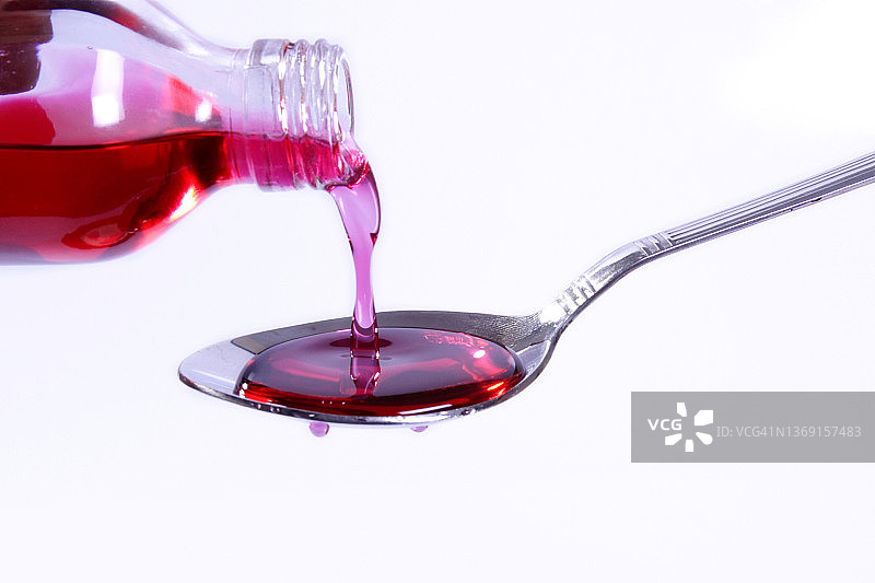 将药用糖浆倒入勺子中图片素材