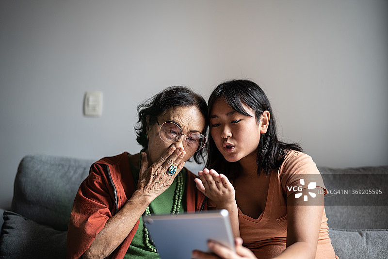 祖母和孙女在家使用平板电脑进行视频通话图片素材