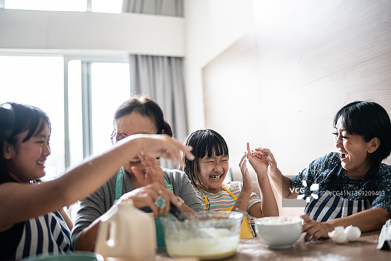 幸福家庭在家准备蛋糕时制造混乱图片素材
