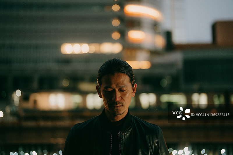男子在东京的夜晚沉思图片素材