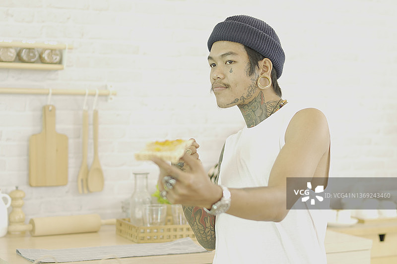 展示涂有果酱面包的纹身男人图片素材