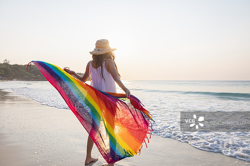 站在海滩上拿着布料的女人图片素材