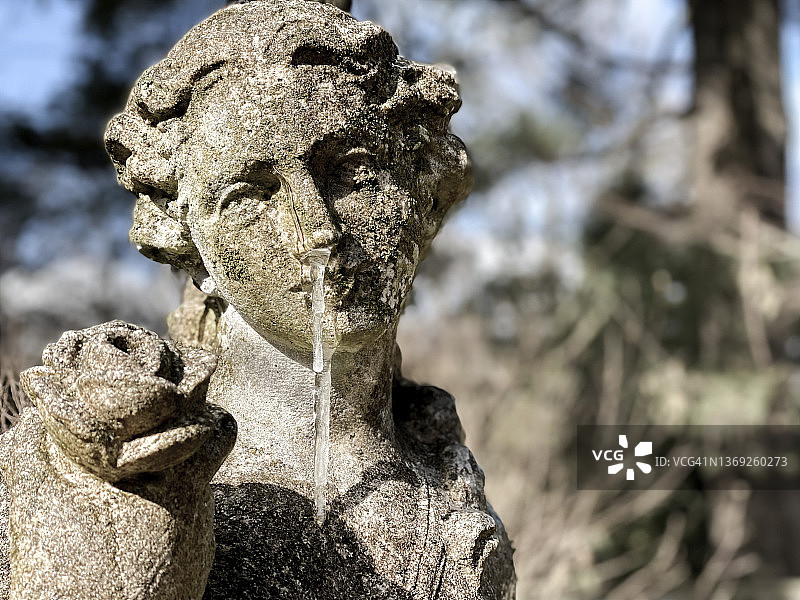 艺术模仿疫情生活的讽刺：花园雕像的鼻子和嘴巴上挂着冰柱图片素材