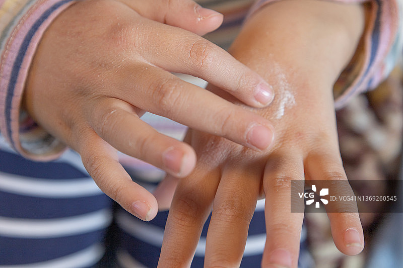 涂抹护手霜的混血女孩图片素材